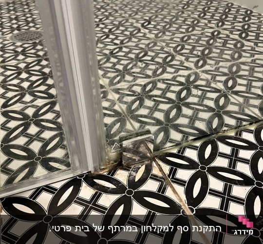 תקריב של גומיית אטימה וציר תחתון במקלחון זכוכית